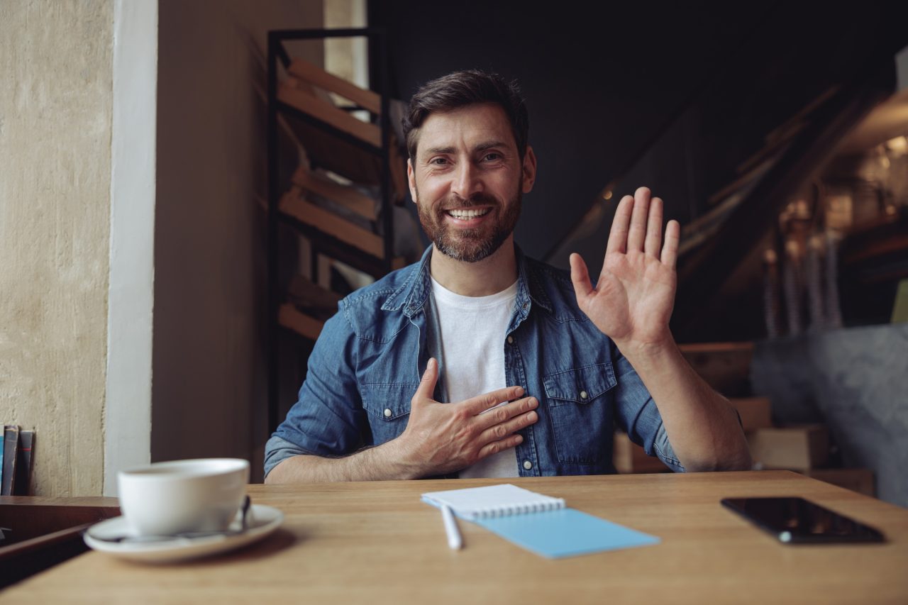 Young handsome man with hand on chest making oath promise gesture in cafe promissing concept.jpg